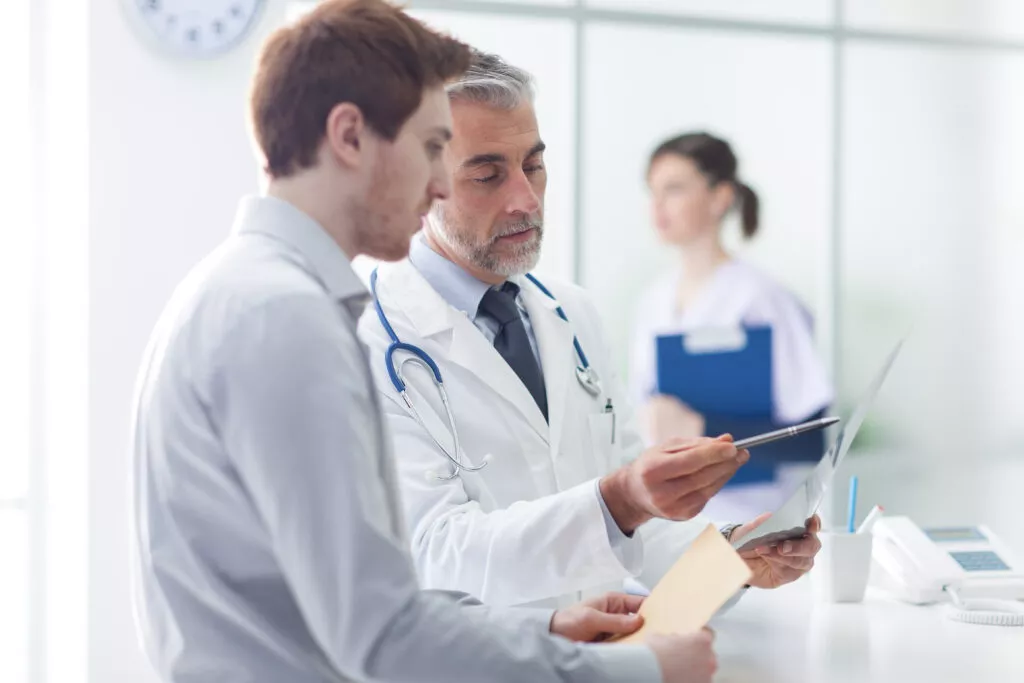 Doctor examining patient's documents during CQC inspection